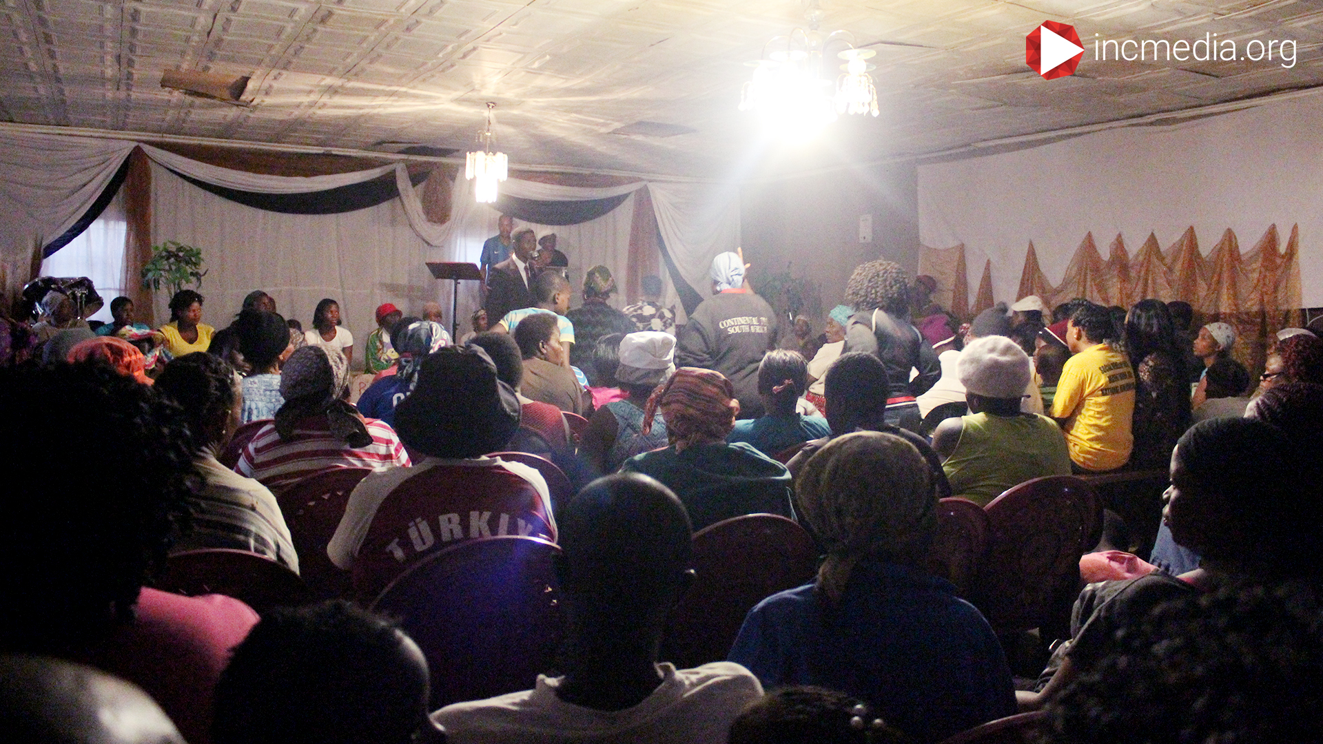 minister in south africa preaching to a crowded room