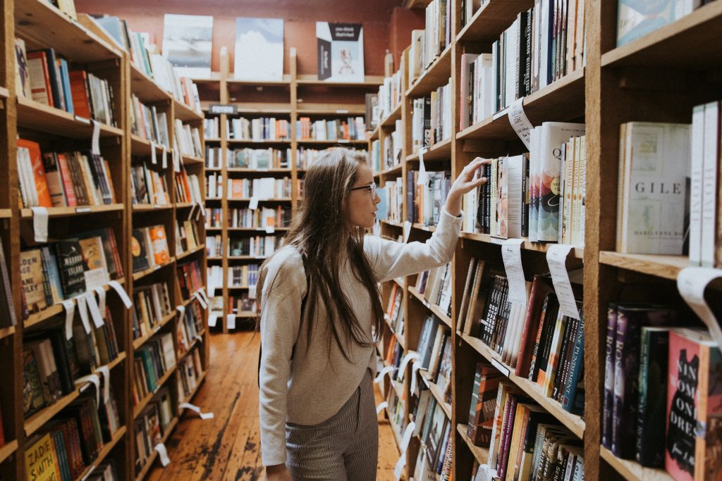 2. Girl looking at books at bookstore.