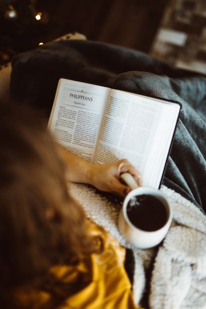 6. Girl reading Bible with cup of coffee.