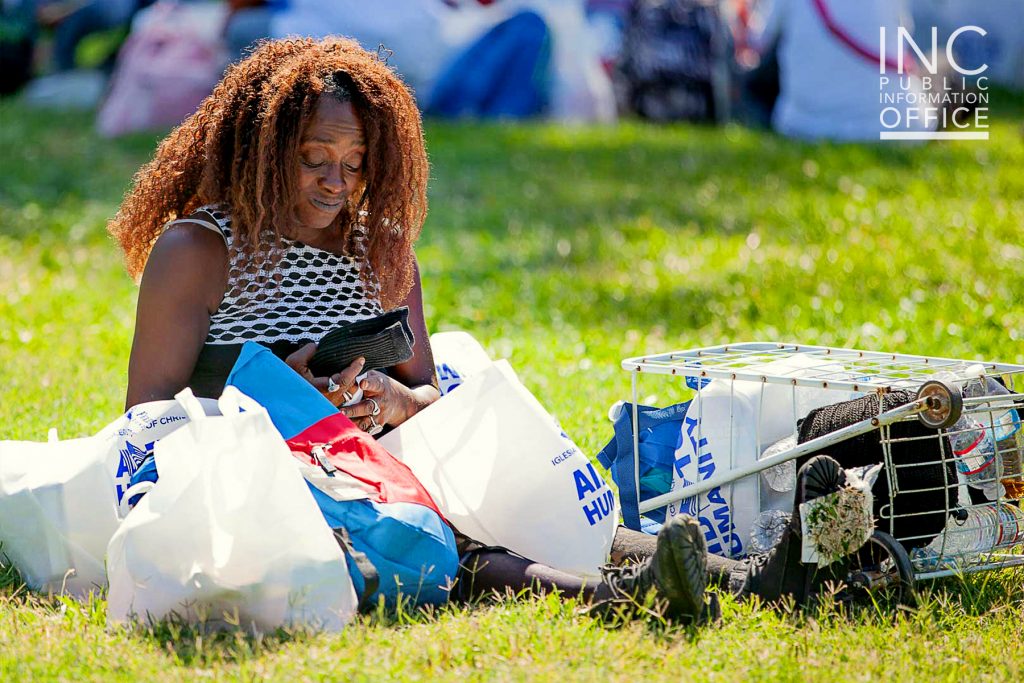 An Oakland resident unpacks the care packages she receives, examining the free new pair of socks she received.